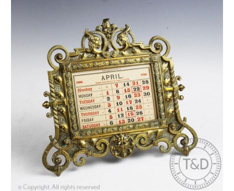 A Victorian cast brass calendar, with elaborate scroll frame and month card inserts for 1935, 25cm wide, with a similar cast 