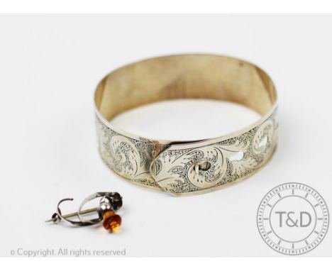 A silver bangle Charles Horner, Chester 1945, with scrolling foliate design and of belt form, along with a Charles Horner bro