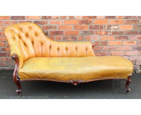 A Victorian carved rosewood chaise longue, with button back tan leather upholstery, on scroll legs, 85cm H x 185cm W