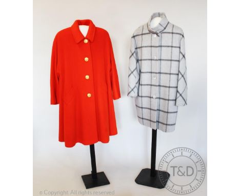 A  bright orange mid length coat, bearing label for 'Jaeger', the simple collared coat with satin lined interior and large go