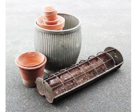 A galvanized wash tub / garden planter, with a selection of terracotta garden plant pots and two cast iron corner hay racks (