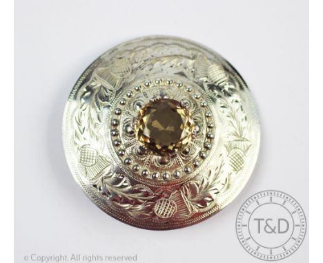 A Scottish silver and quartz set cloak pin, designed as a circular panel engraved with thistles, with beaded central detail, 
