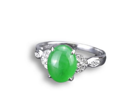 AN 18KT WHITE GOLD, DIAMOND AND JADEITE RING. An oval shaped cabochon mounted in white gold and diamond setting, stamped 18K 