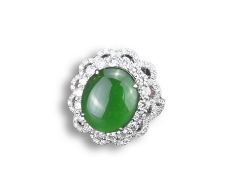 AN 18CT WHITE GOLD, DIAMOND AND JADEITE DRESS RING. An oval shaped cabochon mounted in white gold and diamond setting stamped