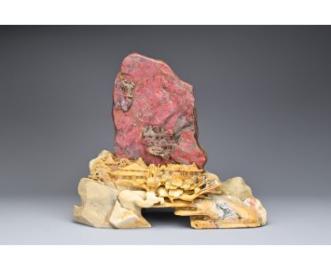 A CHINESE SOAPSTONE BOULDER ON STAND. The stone boulder carved in relief with landscape scene attached to a soapstone base ca