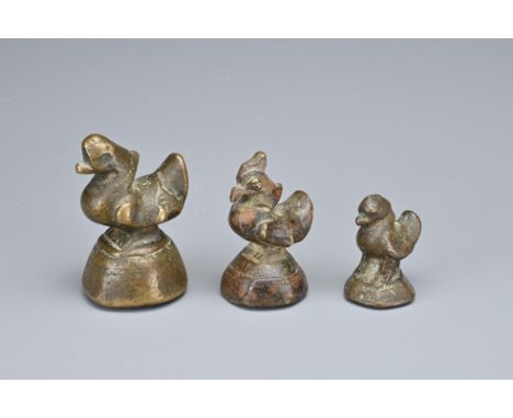 THREE BURMESE BRONZE OPIUM WEIGHTS, 19TH CENTURY OR EARLIER. Of graduating sizes in the form of standing ducks. Weighing 80.1