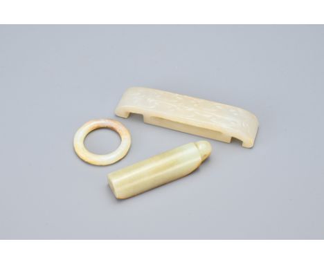 THREE CHINESE PALE CELADON JADE ITEMS. Comprising a Mandarin hat piece; a sword fitting, wei, carved in shallow relief; toget