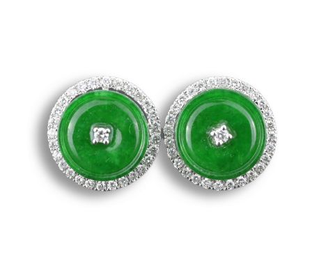 A PAIR OF 18KT WHITE GOLD, DIAMOND AND JADEITE EARRING STUDS. Each disc-shaped and centred with a diamond, within white gold 