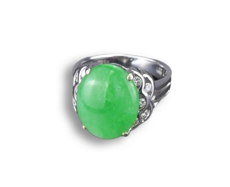 AN 18KT WHITE GOLD, DIAMOND AND JADEITE DRESS RING. With oval shaped cabochon, in pierced white gold and diamond setting, sta