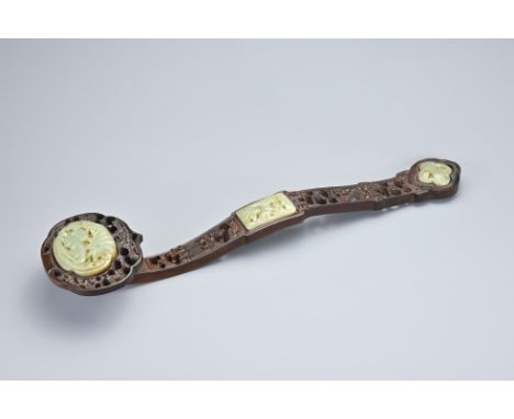 A VINTAGE CHINESE RUYI SCEPTRE. Carved and pierced wood sceptre with celadon jade inserts to the head and handle depicting an