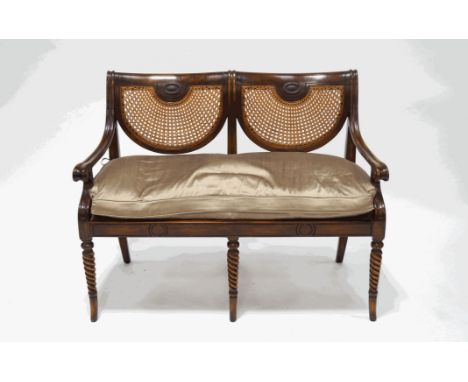 A Regency style mahogany double chair back sofa, with cane seat and back panels, scroll arms and rope twist legs, 15cm wide