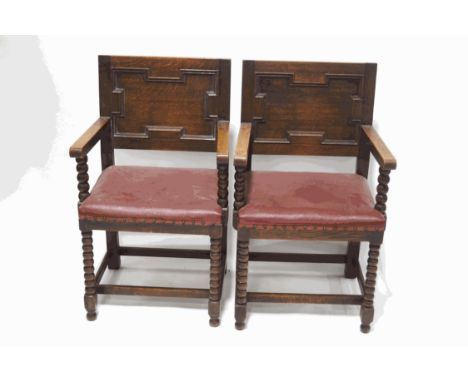A pair of oak elbow chairs with leatherette seats, bobbin turned supports and legs linked by stretchers