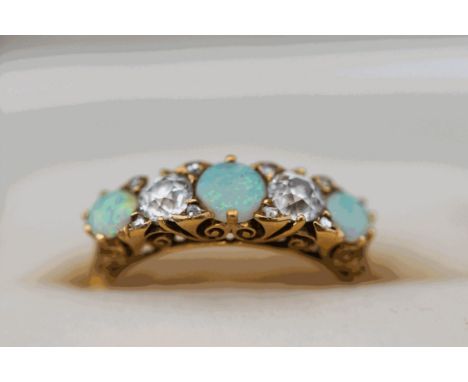 An opal and diamond five stone ring, stamped '18ct', the three round cabochons with two diamonds totalling approximately 0.5 