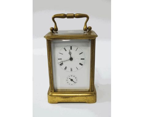 A large brass carriage clock with alarm, striking on a bell, 16cm high (handle up), with key