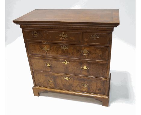 A walnut chest of three short and three long drawers with brass handles and bracket feet (probably formerly part of a George 