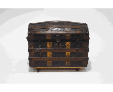 A wooden and metal bound domed trunk, with metal crocodile skin effect panels, interior tray, 61cm high x 73cm wide x 40cm de