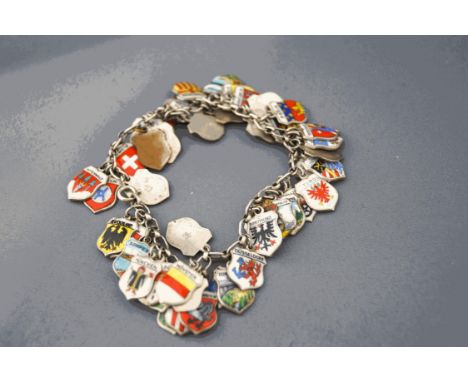 A bracelet of continental enamel souvenir charms, of shield shape bearing town/city coats of arms, scenes eetc, 55g gross