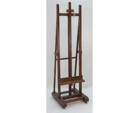 GOOD OAK PICTURE EASEL with adjustable support on casters, 210cms high