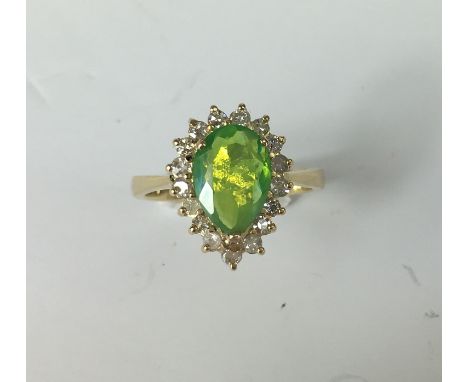 GREEN OPAL AND DIAMOND CLUSTER RING.
An 18ct yellow gold teardrop shaped green Opal and Diamond ring. The central Opal weighi