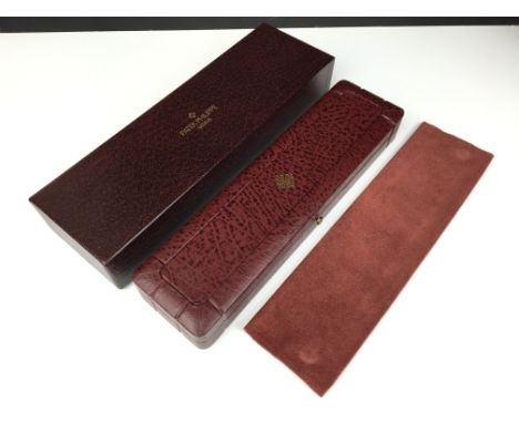 A Patek Philippe burgundy leather watch case with soft cream interior together with soft leather pouch and card protection bo