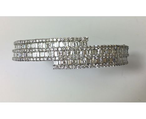 DIAMOND BANGLE
An 18ct white gold Diamond set bangle set with forty two baguette cut Diamonds, forty three princess cut Diamo
