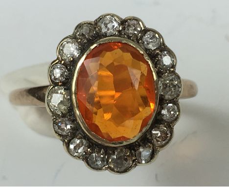 MEXICAN FIRE OPAL AND DIAMOND CLUSTER RING.
A marked 9ct gold Mexican Fire Opal and Diamond cluster ring.  The central orange