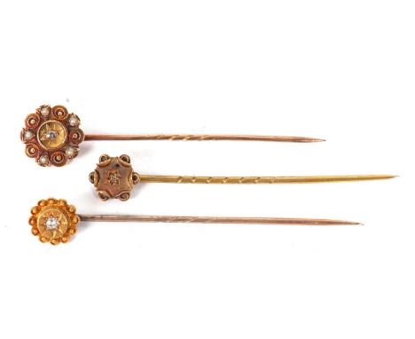 Three 15ct and diamond stick pins: to include a two tone pin stamped 15ct, and two single stone diamond pins both stamped 15c