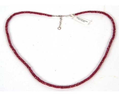 A ruby bead necklace, the slightly graduated faceted beads with clasp stamped 375, 50cm long, 20g