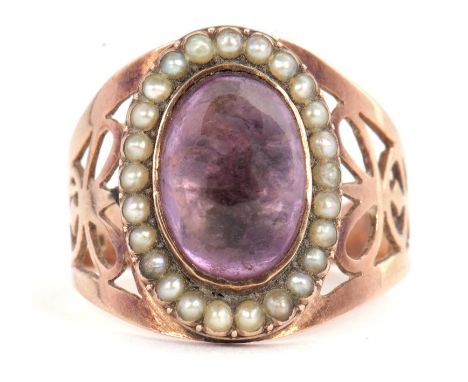 An amethyst and seed pearl ring, the oval collet mounted amethyst cabochon, surrounded by seed pearls, 17mm deep, with broad 