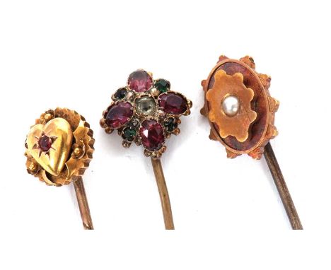 Three cased stick pins: to include a 15ct red stone heart pin stamped 15ct, 1.4g; an unmarked yellow metal and seed pearl pin