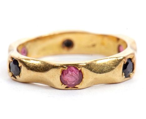A sapphire and ruby ring, the 4mm wide band set with alternating round rubies and sapphires, stamped 18ct, size I-J, 3.9g