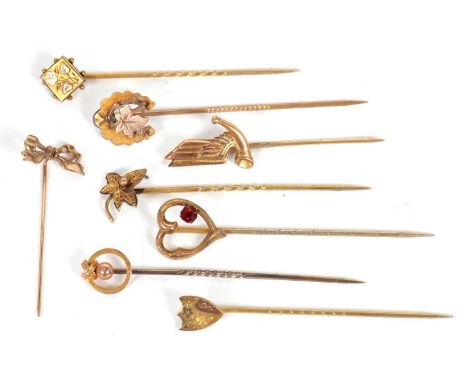 Eight gold and yellow metal stick pins: to include a red paste heart pin, a bow pin, and others, variously marked and unmarke