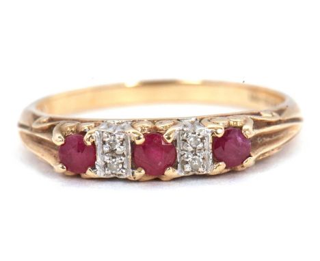 A 9ct ruby and diamond ring, the three round rubies interspaced with diamond highlights, with scrolled gallery and plain band