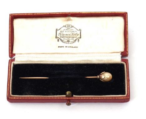 A 'pearl' stick pin, the oval 'pearl', approx. 7.2mm diameter, in a four leaf cup style mount with plain yellow metal pin (te