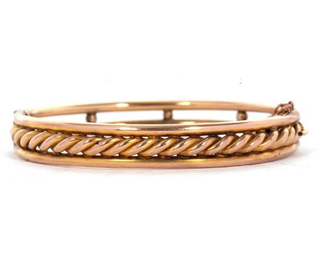 A gold bangle, the hinged bangle set to upper half with rope twist detail and plain band above and below, with plain two row 