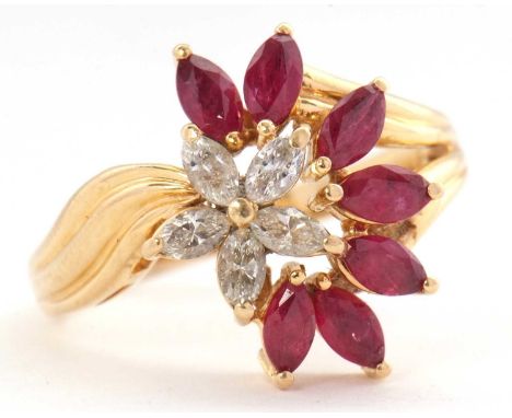 An 18ct ruby and diamond cluster ring, set with marquise rubies and diamonds, with asymetrical reeded shoulders and plain ban
