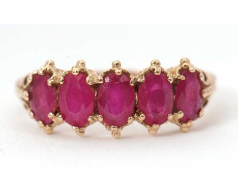 A 9ct five stone ruby ring, the five slightly graduated oval faceted rubies in claw and bead mounts, with tapered shoulders a