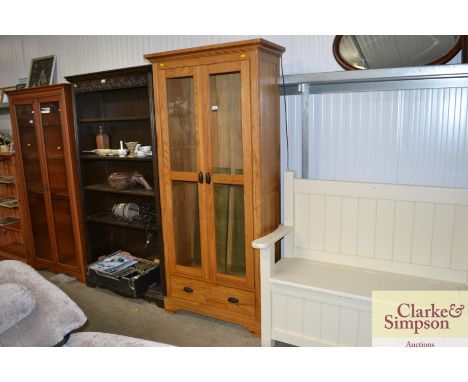 A light oak and glazed cabinet, fitted single drawer below