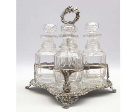 19th Century plated 4 bottle decanter stand of serpentine with floral chased loop handle with 4 glass decanters Condition Rep