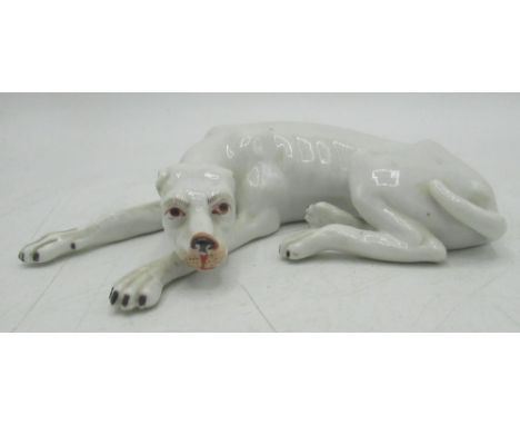 Early C20th Continental model of a recumbent hound, white glazed with black painted detail, L13cm 