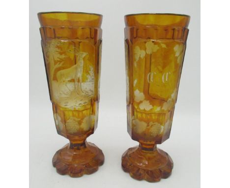 Pair of Bohemian amber glass Hunting goblets, tapering bowls etched in relief panels with Stag, Hound and initials in vine bo