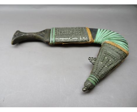 AN ARAB DAGGER (JAMBIYA), 19TH/EARLY 20TH CENTURY with curved medially-ridged blade, horn hilt studded with minute nails, the