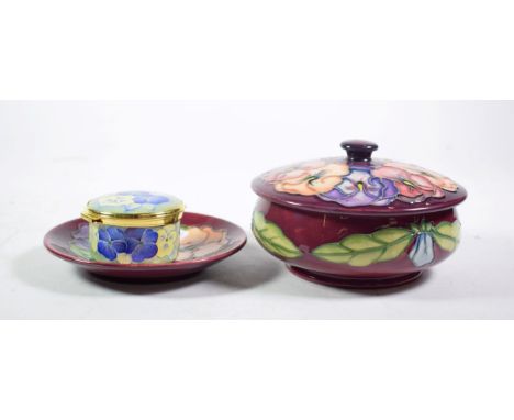 A Moorcroft pottery Pansy pattern circular box and cover on a red ground with impressed marks, 14cm diameter together with a 