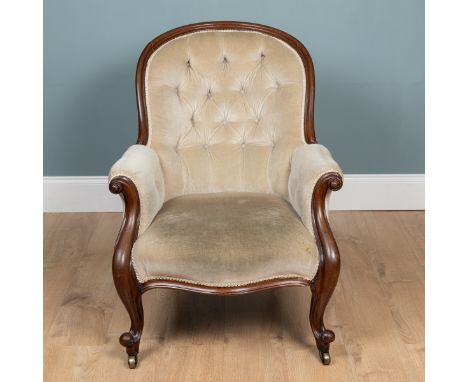 A Victorian mahogany armchair With button-back upholstery, outscrolling arms and legs raised on brass castors. 70cm wide x 95