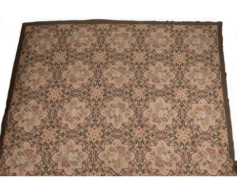 A 19th century Scottish needlepoint carpet With an all-over pattern of floral sprays within shaped cartouches on a green grou