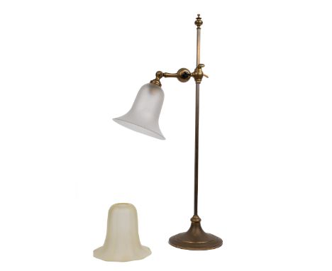 A Faraday & Sons brass adjustable table lamp With glass shade, on a circular spreading base, and with a further spare vaselin