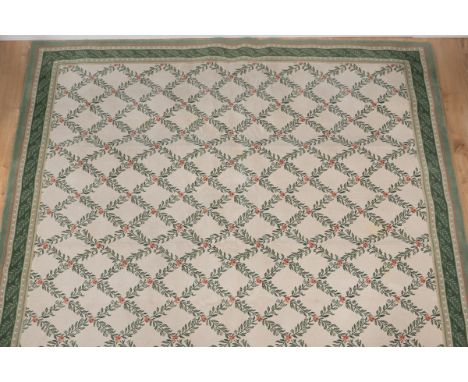 A modern carpet With an all-over geometric rose pattern on a cream ground surrounded by a guarded border. 322cm x 287cmQty: 1