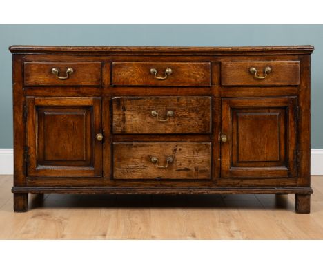An 18th century oak dresser With an arrangement of five drawers and two cupboards with panelled doors.148cm wide x 47cm deep 