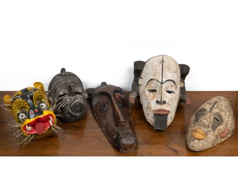 A collection of four African carved masks and one further mask  The lot to comprise of two Nigerian masks; one Congolese mask