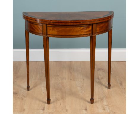 A George III satinwood inlaid demi-lune card table The radiating inlaid top with kingwood cross-banding opening to reveal a g